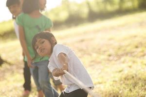 enfants jouant au tir à la corde au parc au coucher du soleil photo