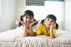 mignons enfants asiatiques allongés sur le lit photo