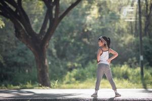 une petite fille exerçant sous une lumière vive et ensoleillée. photo