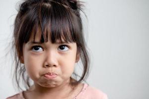 Petite fille en colère sur fond blanc, concept de signe et de geste photo