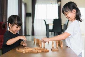 deux filles asiatiques jouant des piles de bois à la maison photo