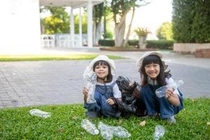 deux petites filles asiatiques sont des poubelles séparées à recycler photo