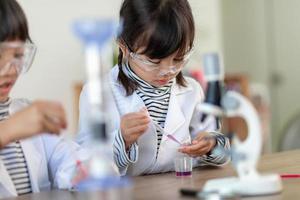 concept d'éducation, de science, de chimie et d'enfants - enfants ou étudiants avec expérience de fabrication de tubes à essai au laboratoire de l'école photo