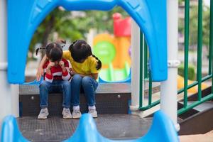 petite fille réconfortant sa soeur à l'aire de jeux photo