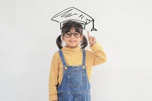 heureux écolier asiatique diplômé en chapeau de graduation photo