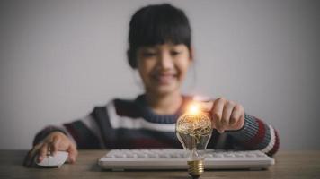 enfant enfant avec une ampoule lumineuse. concept d'idées pour présenter de nouvelles idées grande inspiration et innovation nouveau départ. photo