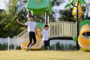 deux petites filles asiatiques s'amusant sur une aire de jeux à l'extérieur en été photo