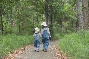 les enfants se dirigent vers le camping familial en forêt à pied le long de la route touristique. route des campings. concept de vacances de voyage en famille. photo