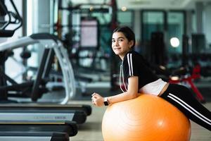 photo de belle jeune femme sportive. fille travaillant avec un ballon de fitness