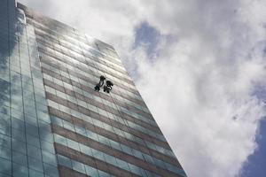groupe de travailleurs nettoyant le service des fenêtres sur un immeuble de grande hauteur photo
