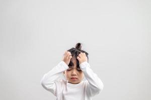 triste petite fille tient sa tête. petite fille se sentant malade, ayant des maux de tête. photo