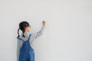 petits enfants peignant sur un mur blanc photo