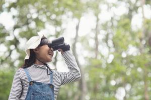 enfant heureux à l'avenir. enfant souriant avec les jumelles. concept de voyage et d'aventure. liberté, vacances photo