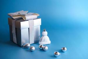 cadeau argenté avec réveil blanc et décorations de noël sur fond bleu photo