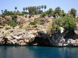 vue sur les falaises de la montagne avec la grotte de la ville d'antalya, turquie photo