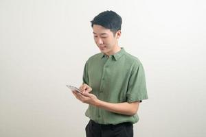 jeune homme asiatique utilisant ou parlant un smartphone et un téléphone portable photo
