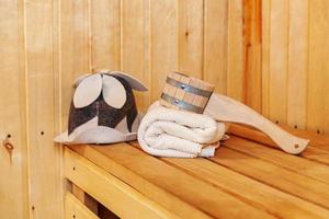 détails intérieurs sauna finlandais hammam avec accessoires de sauna traditionnels scoop chapeau de feutre serviette. ancien concept de spa de bain traditionnel russe. Détendez-vous le concept de bain de village de campagne. photo