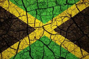 motif de sol sec sur le drapeau de la jamaïque. pays avec concept de sécheresse. problème d'eau. terre sèche fissurée. photo