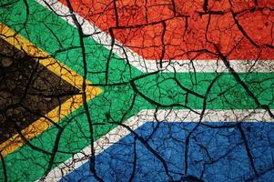 motif de sol sec sur le drapeau de l'afrique du sud. pays avec concept de sécheresse. problème d'eau. terre sèche fissurée. photo