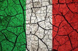 motif de sol sec sur le drapeau de l'italie. pays avec concept de sécheresse. problème d'eau. terre sèche fissurée. photo