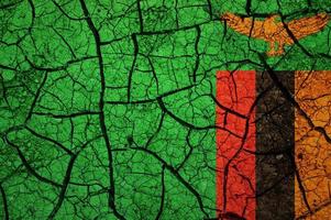 motif de sol sec sur le drapeau de la zambie. pays avec concept de sécheresse. problème d'eau. terre sèche fissurée. photo
