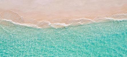 scène de plage aérienne relaxante, bannière de modèle de vacances de vacances d'été. les vagues surfent avec un incroyable lagon bleu océan, bord de mer, littoral. vue de dessus de drone aérien parfait. plage lumineuse paisible, bord de mer photo