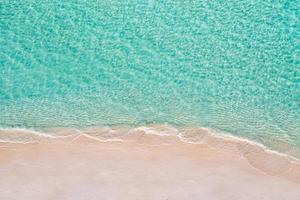 scène de plage aérienne relaxante, bannière de modèle de vacances de vacances d'été. les vagues surfent avec un incroyable lagon bleu océan, bord de mer, littoral. vue de dessus de drone aérien parfait. plage lumineuse paisible, bord de mer