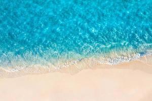 scène de plage aérienne relaxante, bannière de modèle de vacances de vacances d'été. les vagues surfent avec un incroyable lagon bleu océan, bord de mer, littoral. vue de dessus de drone aérien parfait. plage lumineuse paisible, bord de mer photo