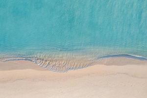 scène de plage aérienne relaxante, bannière de modèle de vacances de vacances d'été. les vagues surfent avec un incroyable lagon bleu océan, bord de mer, littoral. vue de dessus de drone aérien parfait. plage lumineuse paisible, bord de mer photo