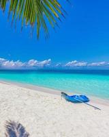 plage de l'île des maldives avec kayak bleu sur le rivage. paysage tropical d'été, sable blanc avec palmiers. destination de vacances de voyage de luxe. paysage de plage exotique. nature incroyable, détente, liberté
