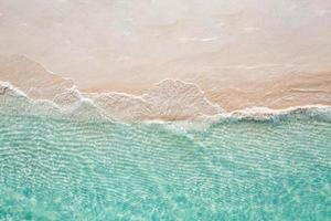 scène de plage aérienne relaxante, bannière de modèle de vacances de vacances d'été. les vagues surfent avec un incroyable lagon bleu océan, bord de mer, littoral. vue de dessus de drone aérien parfait. plage lumineuse paisible, bord de mer