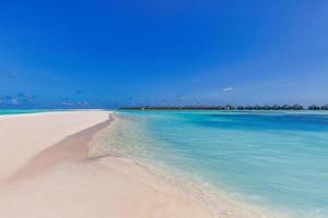 beau paysage panoramique de villas sur pilotis, île des maldives, océan indien. vacances tropicales de luxe, lagon exotique, eau cristalline, mer de ciel bleu relaxant. paradis du tourisme de voyage d'été photo