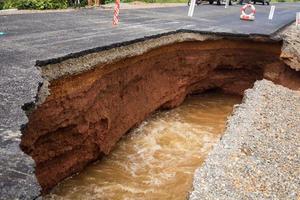 la route a été détruite par l'érosion hydrique causée par de fortes pluies et l'inondation de la route. photo