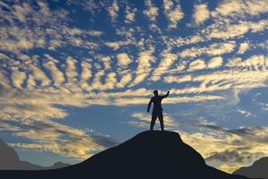 concept de victoire, une silhouette d'un homme debout dans le ciel du coucher du soleil. photo