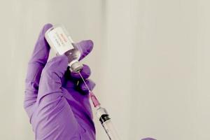 vaccin covid-19 entre les mains de chercheurs femme médecin tenant une seringue et une bouteille de médicament avec vaccin pour injecter l'immunité contre covid 19 photo