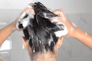 femme asiatique se lavant les cheveux en prenant une douche. photo