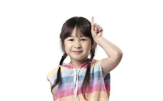 portrait d'une belle jeune fille asiatique pointant vers le haut une main avec le doigt sur la face supérieure avec un visage souriant. la jolie fille se tient debout et regarde la caméra en studio. concept de publicité et de présentation. photo