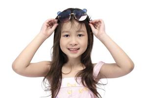 souriante mignonne petite fille asiatique portant des lunettes de mode isolées sur fond blanc. photo