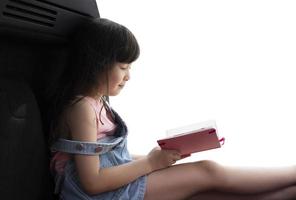 belle fille assise et lisant un livre rose voulant être heureuse, lisant des livres pour apprendre photo
