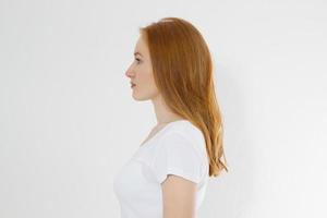 portrait de profil d'une fille caucasienne aux cheveux rouges avec des cheveux féminins longs et brillants isolés sur fond blanc. belle femme modèle européen avec une coiffure droite. espace de copie. photo