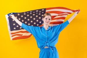 fille caucasienne. heureuse jeune femme en vêtements bleus avec drapeau usa isolé photo