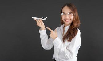 femme d'affaires portant une chemise blanche main tenant un avion jouet blanc. photo
