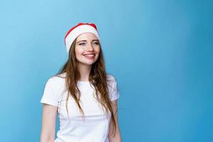 noël santa hat isolé portrait de femme. fille heureuse souriante sur bleu photo