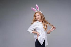jeune belle femme dans de jolies oreilles de lapin de pâques fait un geste normal, joue photo