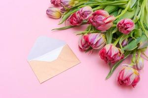 bouquet de belles tulipes et enveloppe dorée sur fond rose, universel photo