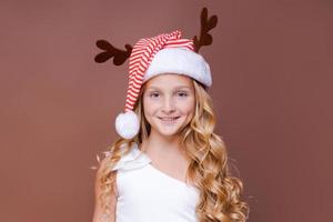 portrait joyeuse jeune adolescente habillée en cerf de noël debout photo