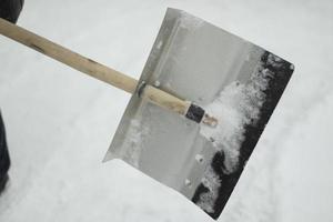 pelle pour le déneigement. pelle à l'extérieur en hiver. nettoyer la piste des congères. photo