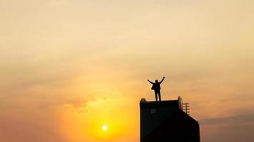 silhouette d'homme sur rofftop sur fond clair de ciel et de soleil, concept d'entreprise, de succès, de leadership, de réussite et de personnes photo
