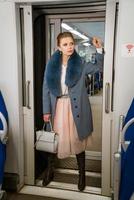 femme à la mode en manteau bleu dans un train photo