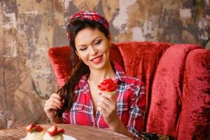 une jeune femme dans un café assis à une table avec des gâteaux, pin up photo